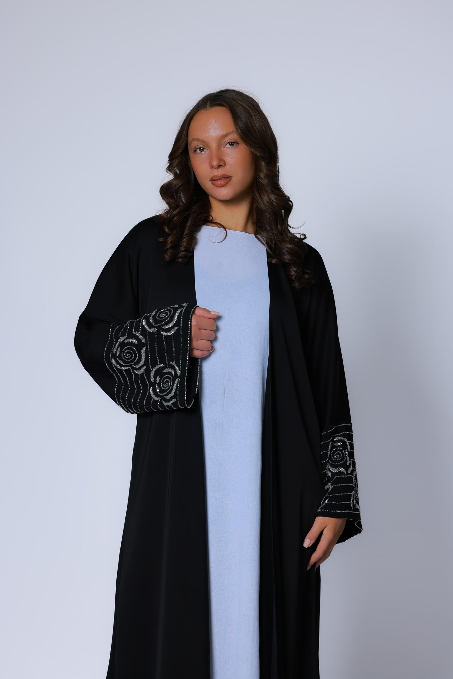 Zwarte abaya met zilveren rozenborduurwerk op de mouwen, gedragen op model, vooraanzicht