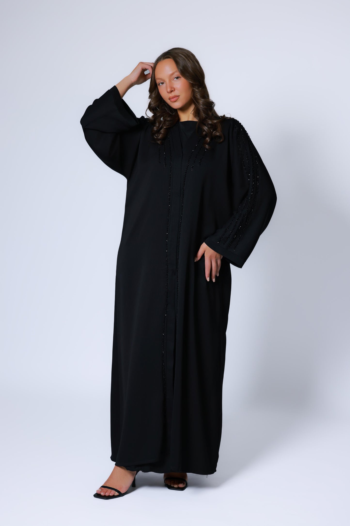 Vooraanzicht van een open zwarte abaya kimono voor dames, afgewerkt met fijne details