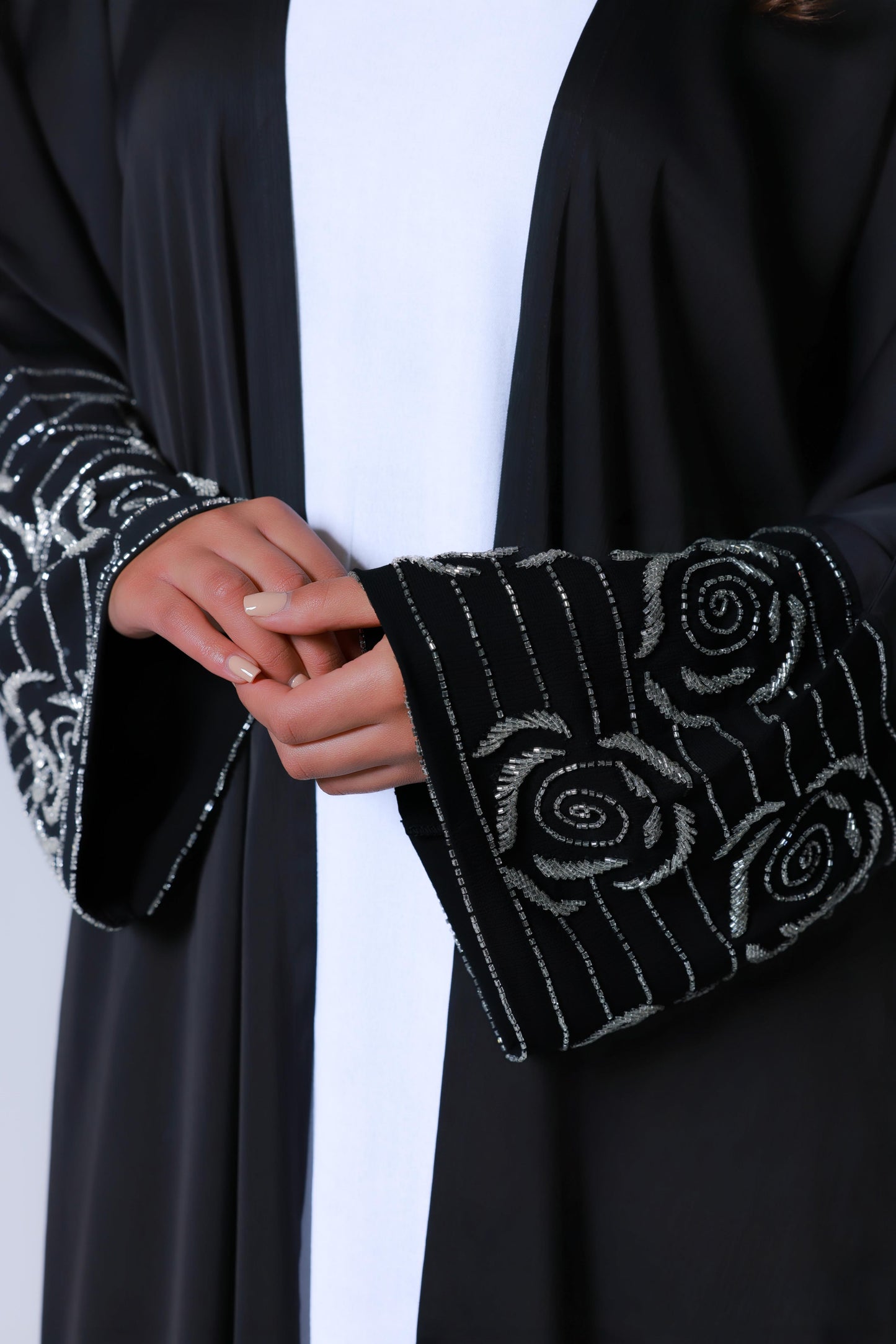 Prachtige afwerking zwarte abaya met witte onderjurk, close up