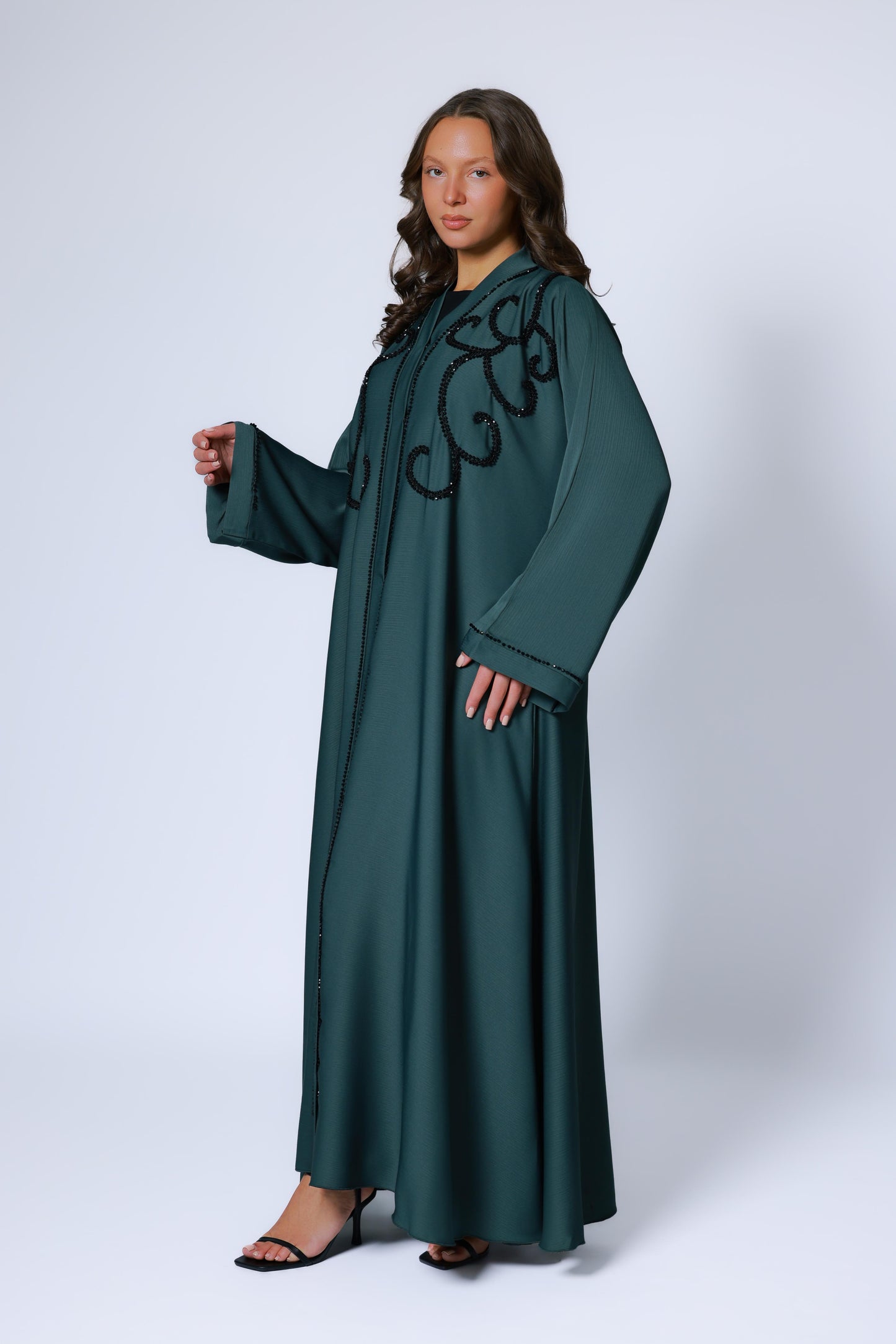 Zijaanzicht van donkergroene abaya met sierlijke steentjes op de mouw