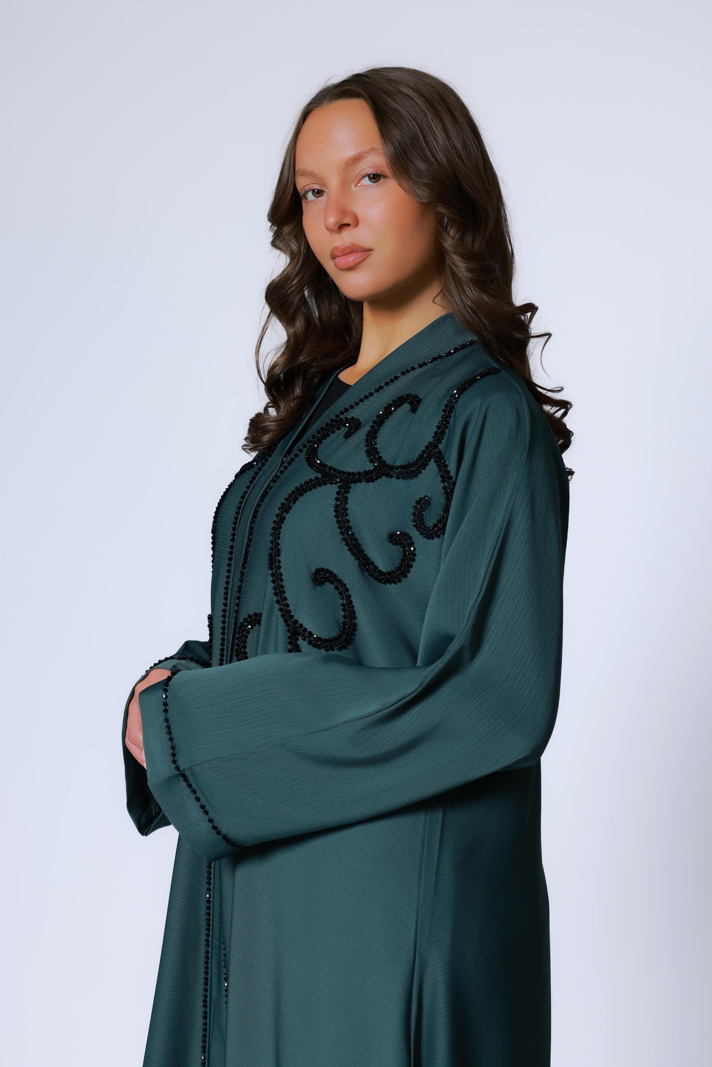 Zijaanzicht van donkergroene abaya met sierlijke steentjes op de voorkant abaya