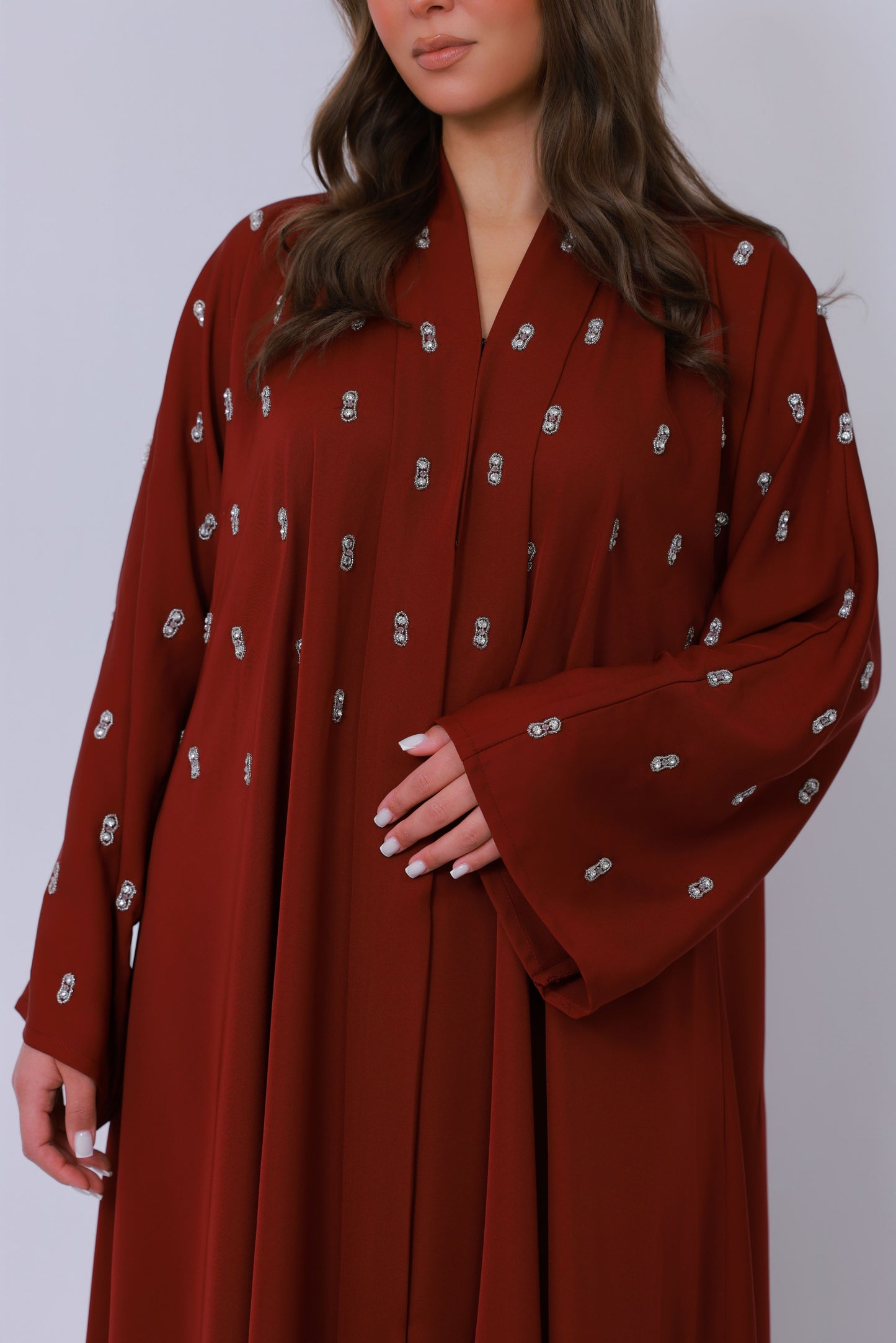 Detail van rode abaya stof met decoratief borduurpatroon