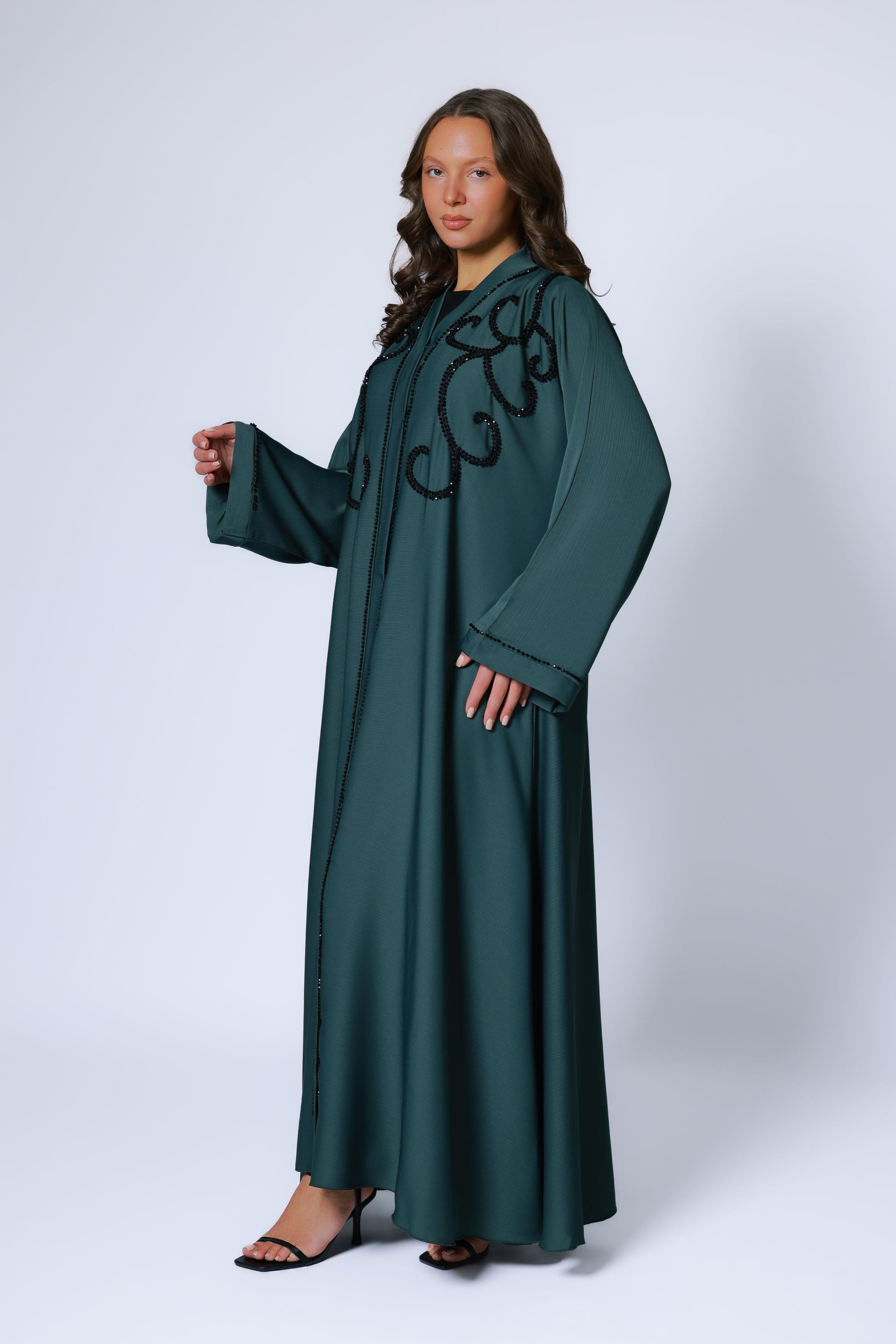 Zijaanzicht van donkergroene abaya met sierlijke steentjes op de mouw