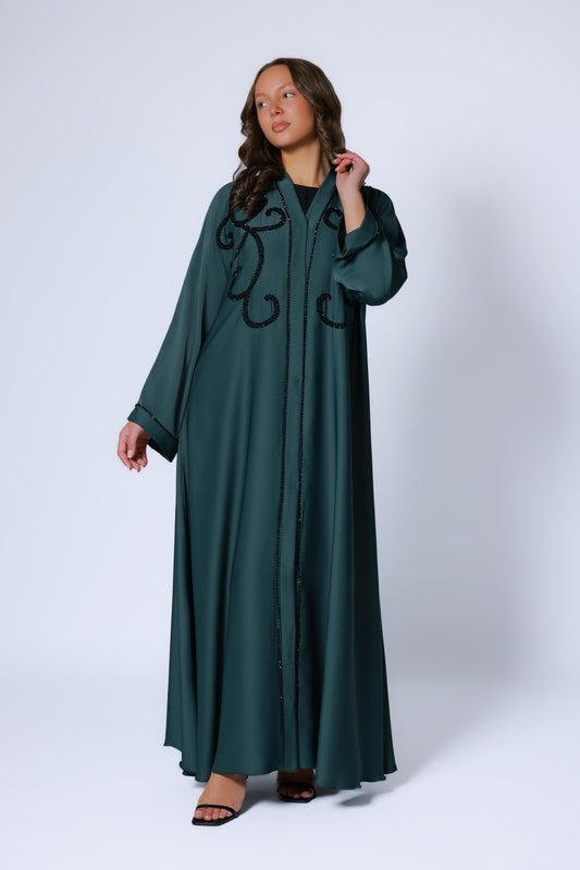 Elegante look met donkergroene abaya met steentjes, gecombineerd met bijpassende hijab en clutch