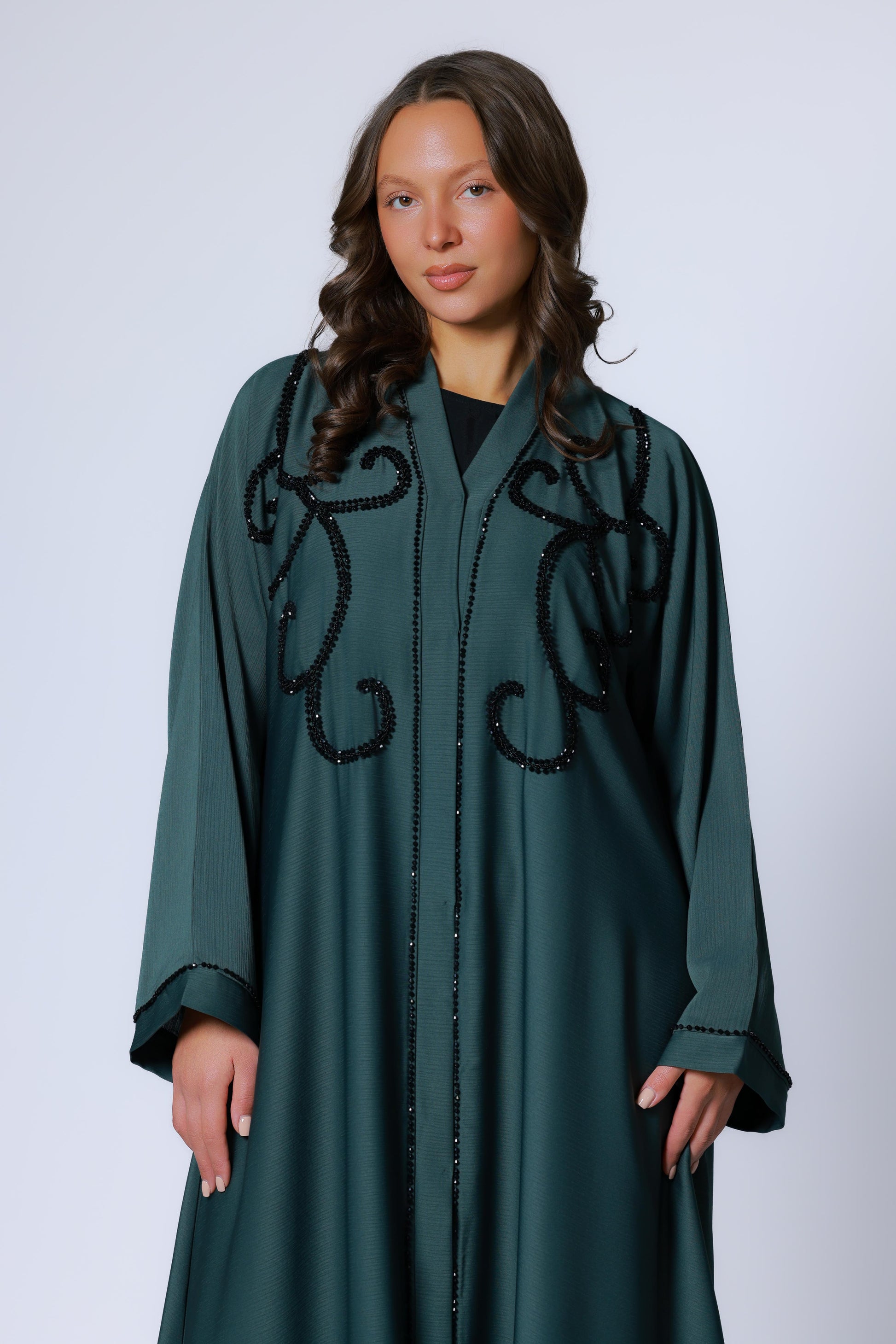 Donkergroene abaya met glinsterende steentjes, gedragen door model – vooraanzicht
