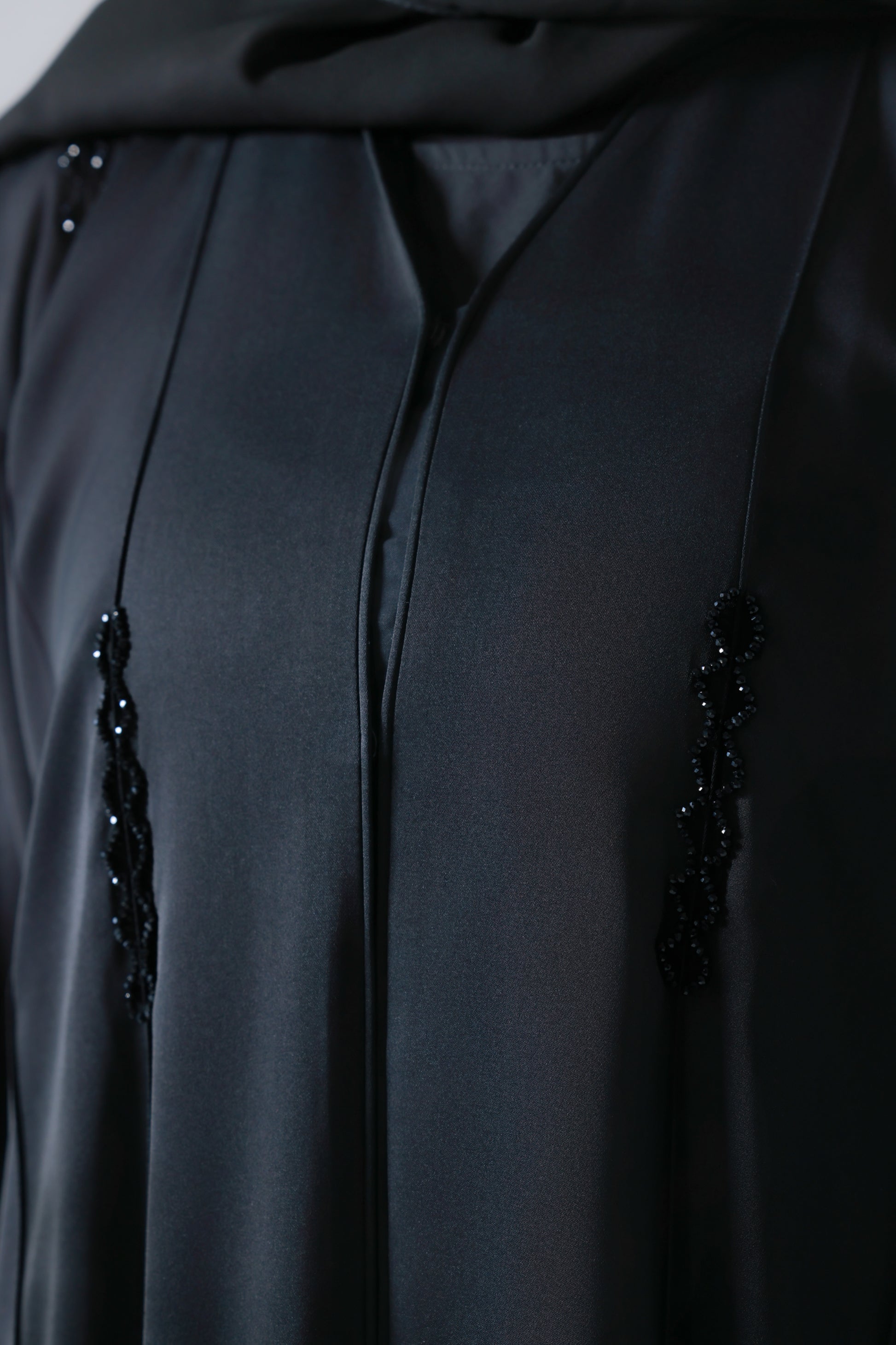 Detailopname van steentjes op zwarte abaya 