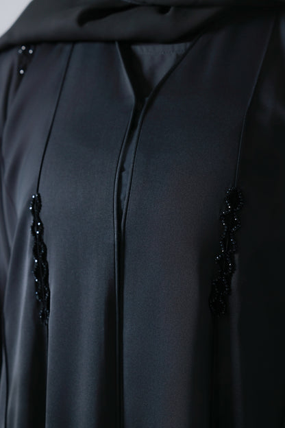 Detailopname van steentjes op zwarte abaya 