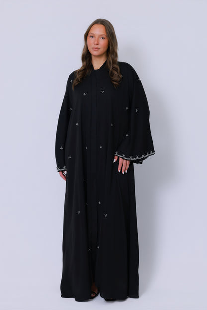 Bovenlichaam van zwarte abaya met minimalistisch borduurmotief en vloeiende stof