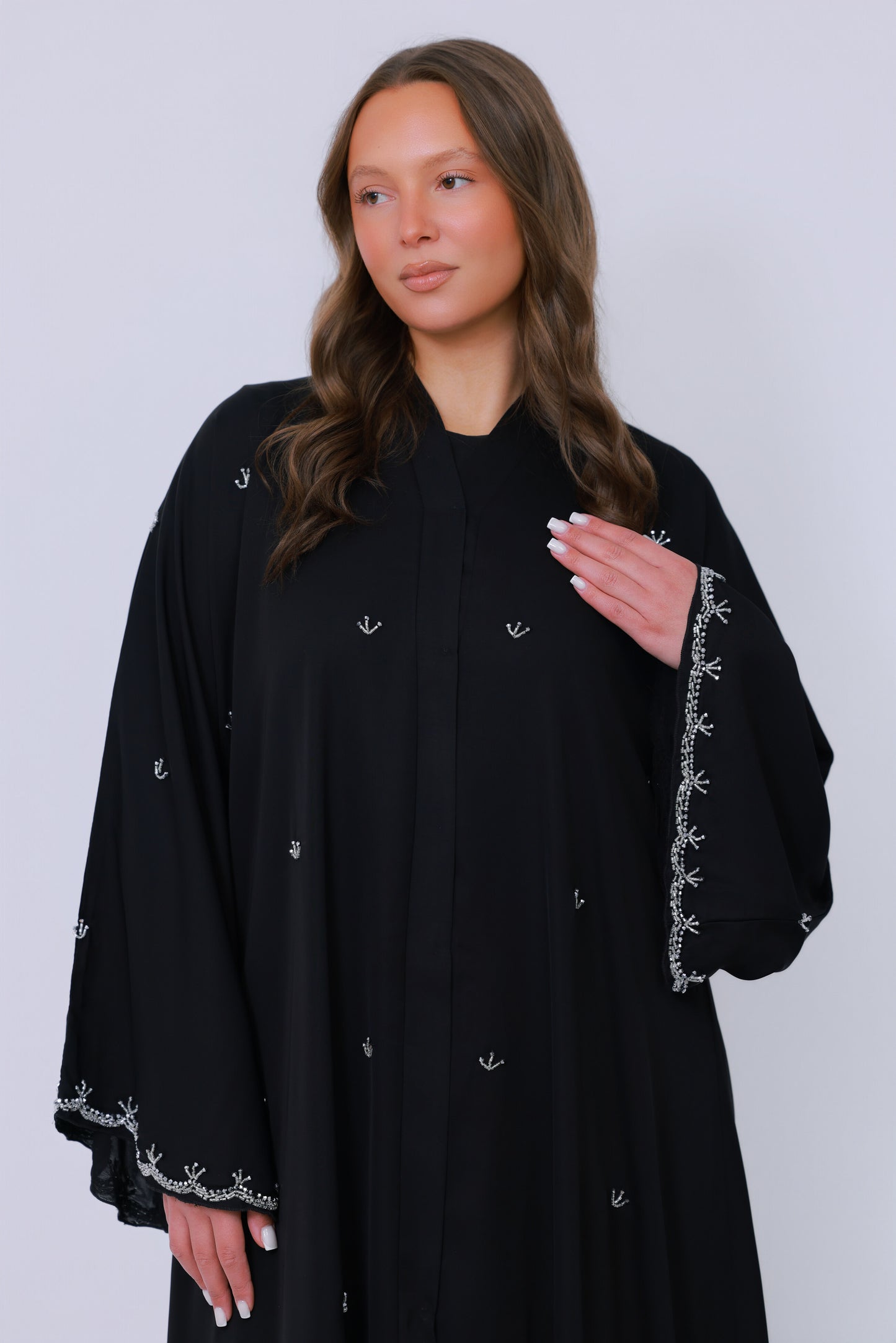 Detail van zwarte abaya stof met kleine geborduurde accenten
