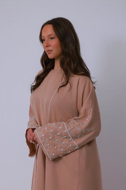 Sand kleurige abaya zijaanzicht met losvallend silhouet en elegante afwerking

