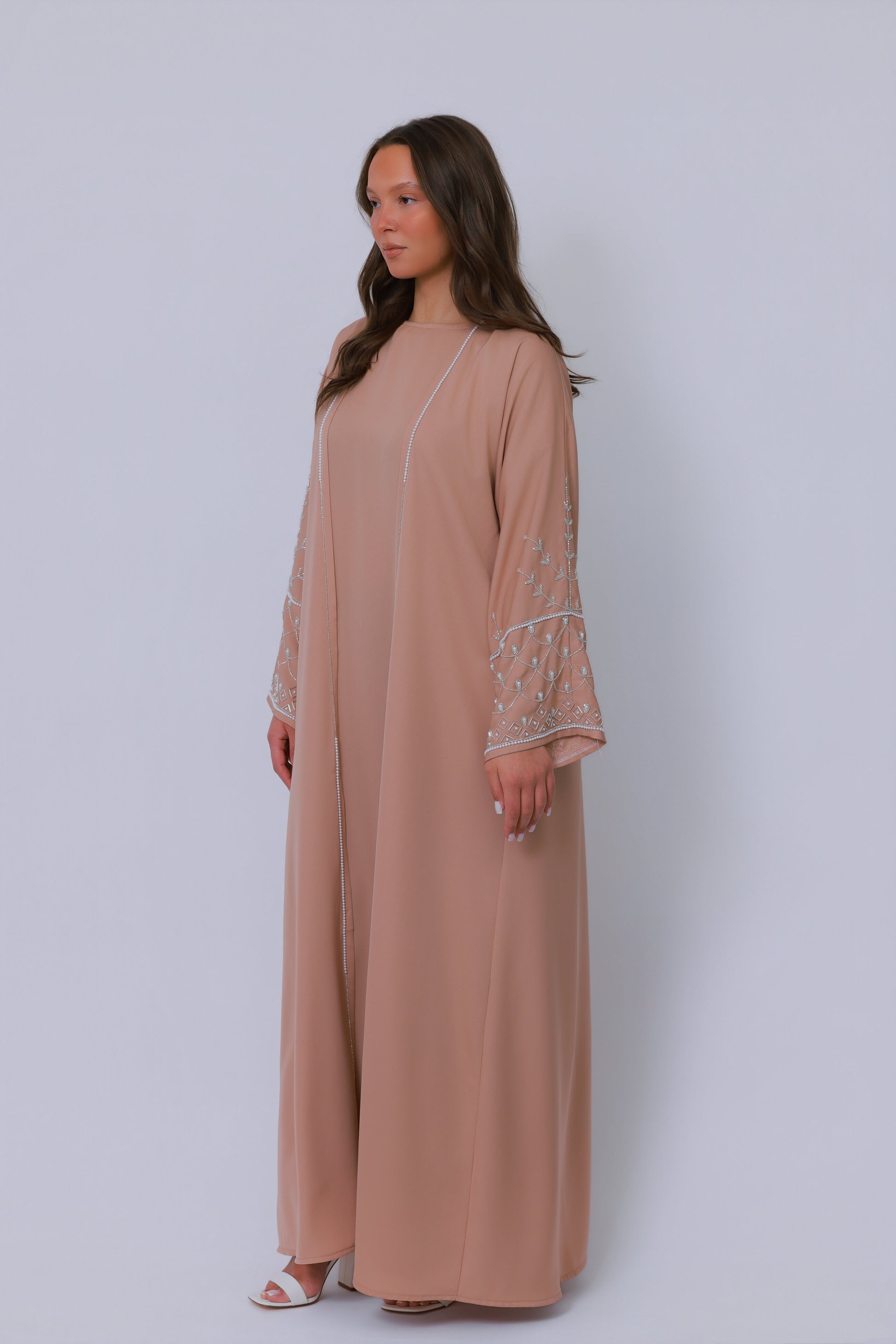 Nude beige open abaya in schuin perspectief met luxe borduurwerk langs de mouwen
